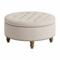 Reposapiés redondo de poliéster beige con capitoné tachuelas metálicas y patas de madera 65 x 65 x 42 cm
